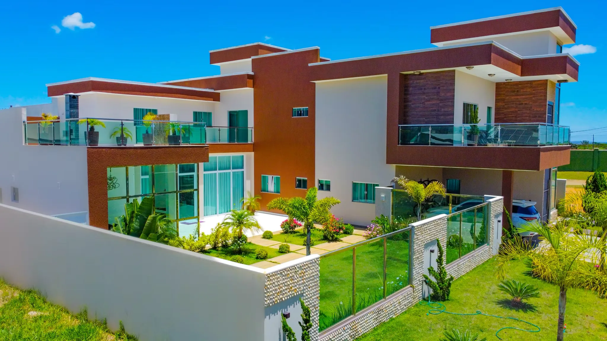 Residência contemporânea com fachada e guarda-corpos em vidro